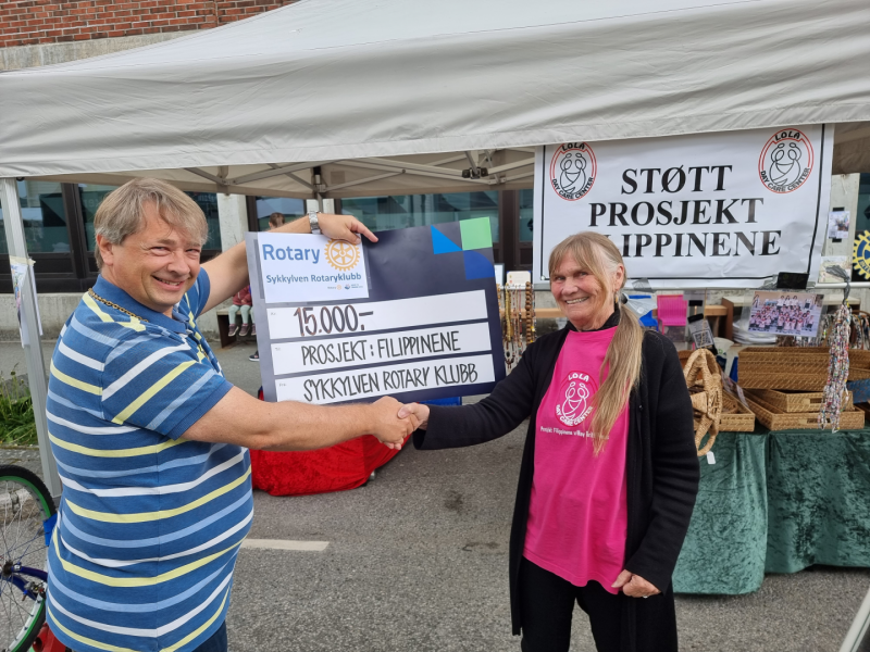 Roger Kornberg overrekker sjekk til Lola Day Care Center